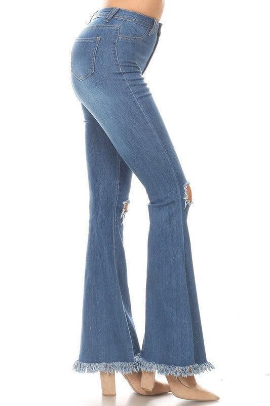 Distressed denim flare jeans with frayed hems, paired with beige heels for women's fashion.