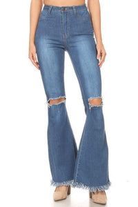 Women's distressed flare denim jeans with frayed hems, styled with neutral heels for a casual chic look.