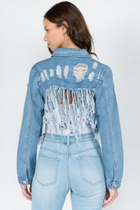 Distressed denim jacket with frayed back detail paired with light wash jeans, perfect for women's fashion looks.